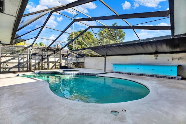 outdoor pool with an in ground hot tub, a patio area, and a lanai