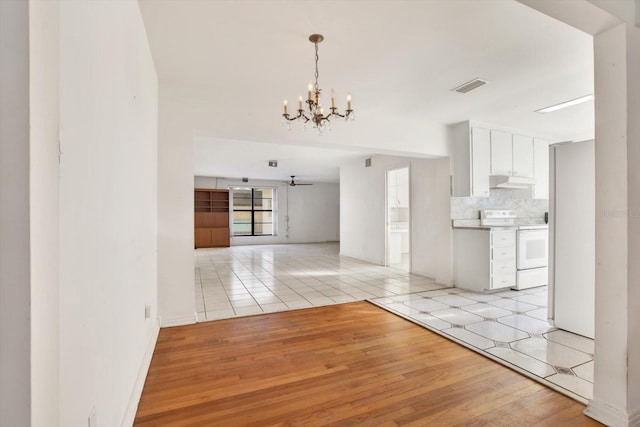 interior space with a chandelier, visible vents, and light wood finished floors