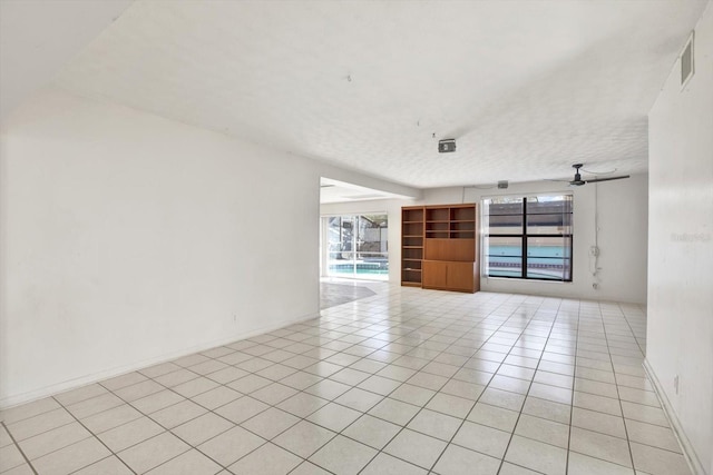 spare room featuring a ceiling fan, visible vents, a textured ceiling, and light tile patterned floors