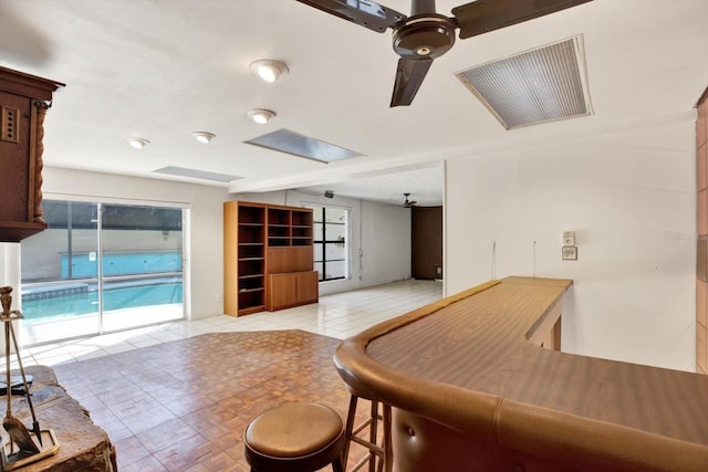 bar featuring a ceiling fan, visible vents, and light tile patterned floors