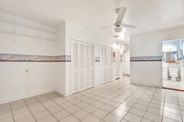 tiled spare room featuring a ceiling fan and visible vents