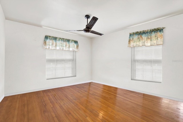 spare room with baseboards, ceiling fan, and hardwood / wood-style floors