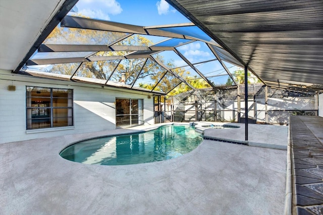 view of swimming pool featuring a patio, a pool with connected hot tub, and glass enclosure