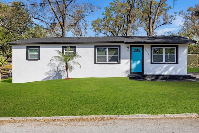 ranch-style home with a front lawn and stucco siding