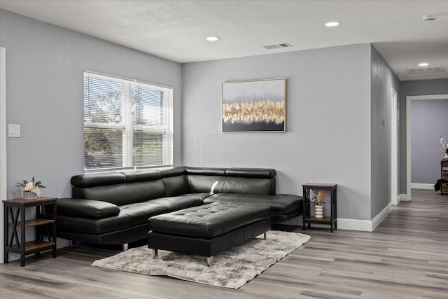 living room with recessed lighting, wood finished floors, visible vents, and baseboards