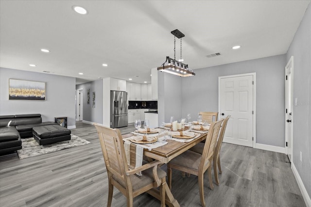 dining room with recessed lighting, baseboards, visible vents, and light wood finished floors