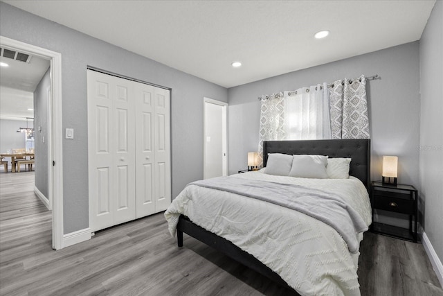 bedroom featuring visible vents, baseboards, wood finished floors, a closet, and recessed lighting