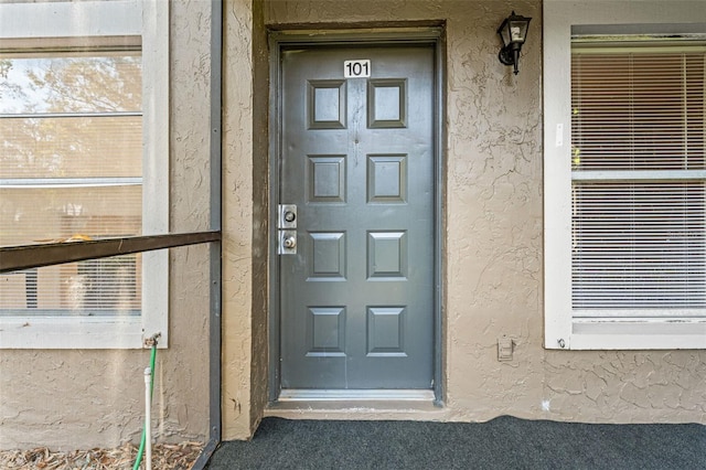 property entrance with stucco siding