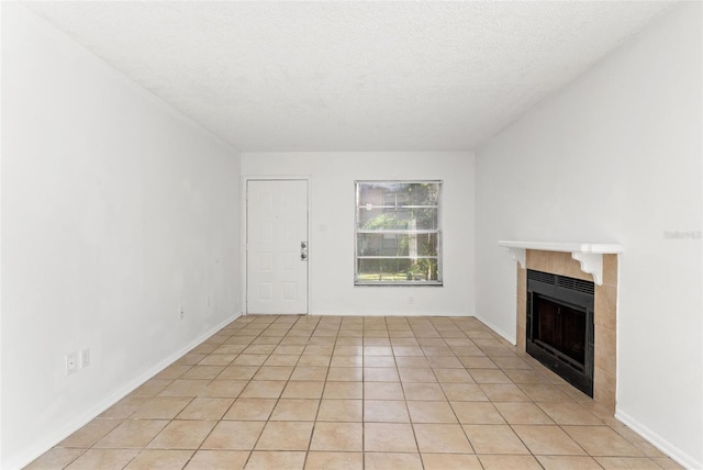 unfurnished living room with a fireplace, a textured ceiling, and light tile patterned flooring