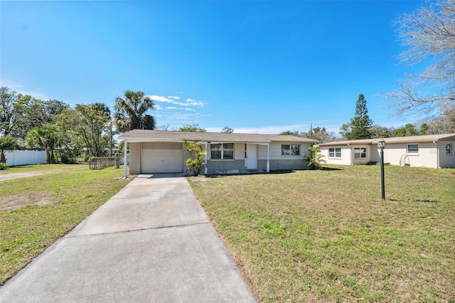 ranch-style house featuring concrete driveway, an attached garage, fence, and a front yard