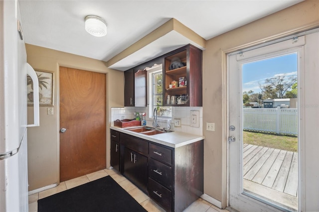 kitchen with plenty of natural light, light countertops, a sink, and backsplash