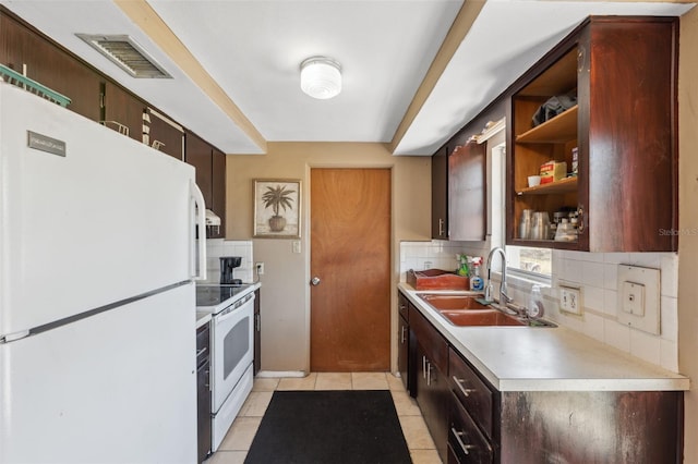 kitchen with white appliances, a sink, visible vents, light countertops, and tasteful backsplash