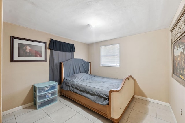 bedroom with baseboards and light tile patterned floors