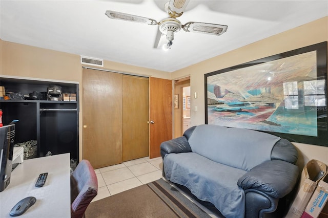 living room featuring light tile patterned floors, visible vents, and a ceiling fan