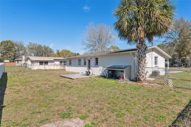 rear view of property featuring a fenced backyard and a yard