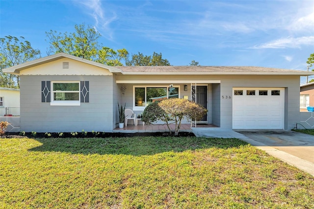 ranch-style home featuring concrete driveway, an attached garage, and a front yard