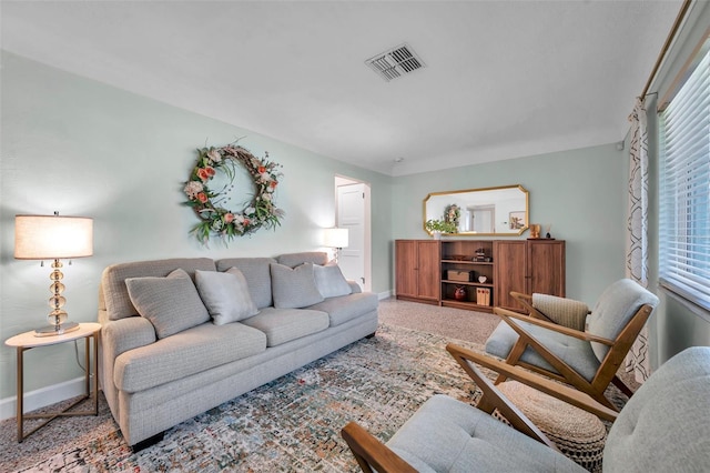 living room with carpet flooring, visible vents, and baseboards