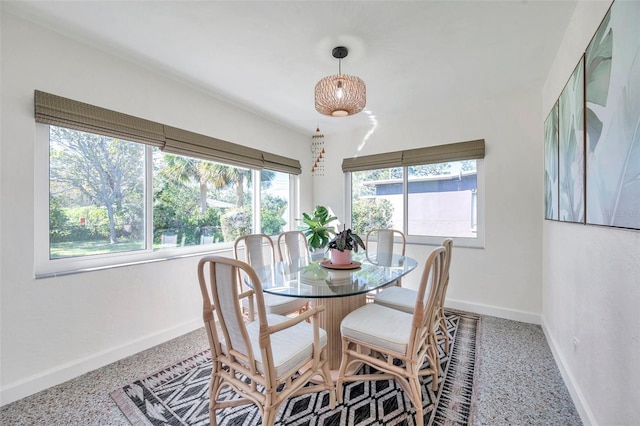 dining room featuring speckled floor and baseboards