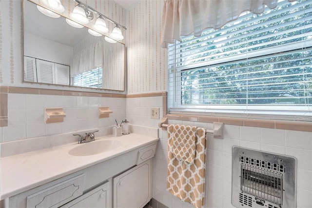 bathroom featuring a wainscoted wall, vanity, tile walls, heating unit, and wallpapered walls