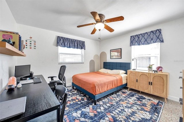 bedroom with ceiling fan, speckled floor, and baseboards