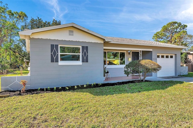 ranch-style home with a front lawn, fence, driveway, and an attached garage