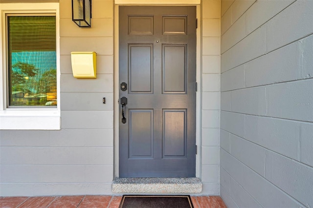 entrance to property featuring concrete block siding