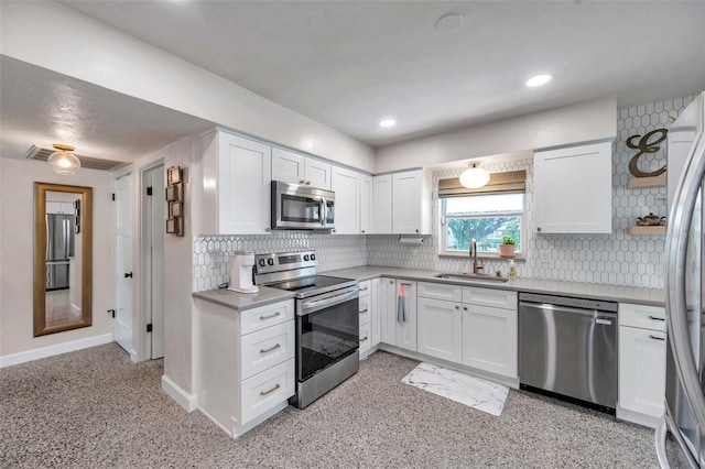 kitchen featuring a sink, baseboards, white cabinetry, and stainless steel appliances