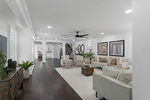 living area featuring wood-type flooring, stairs, arched walkways, and recessed lighting