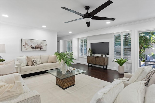 living area with baseboards, dark wood finished floors, crown molding, and recessed lighting