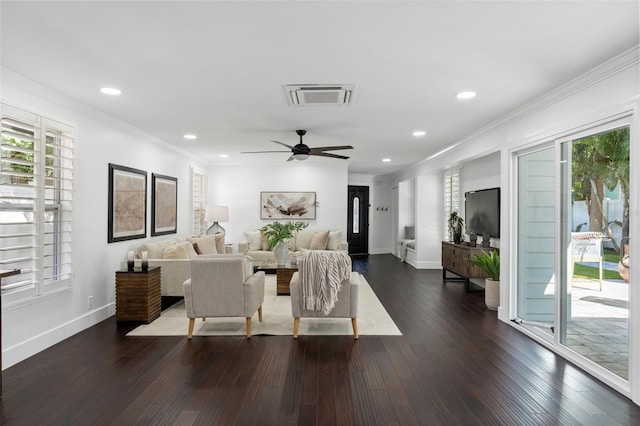 living room featuring dark wood-style floors, a wealth of natural light, ornamental molding, and visible vents