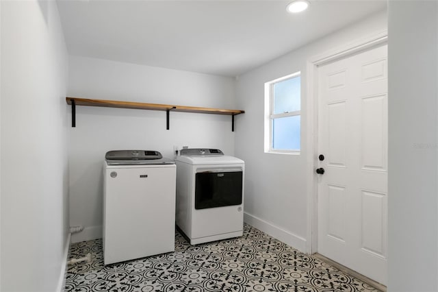 laundry area with laundry area, recessed lighting, washing machine and clothes dryer, and baseboards