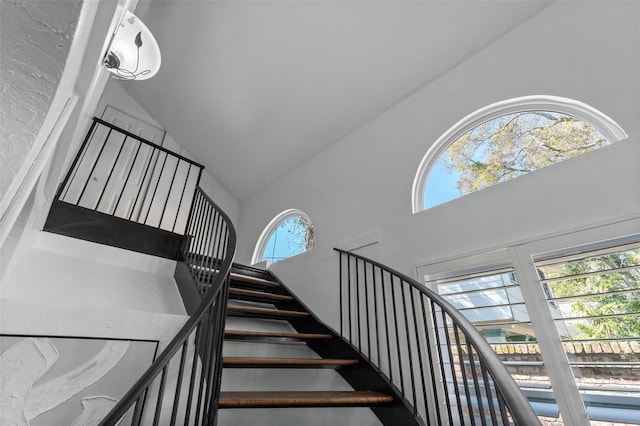 staircase featuring high vaulted ceiling