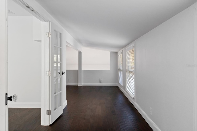 empty room with dark wood finished floors and baseboards