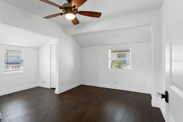 empty room featuring vaulted ceiling with beams, dark wood-style floors, baseboards, and a ceiling fan