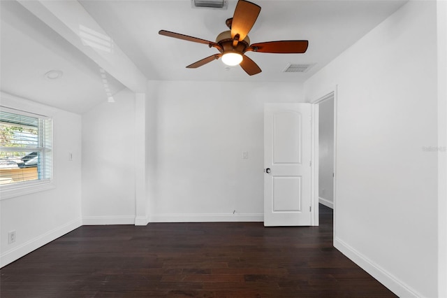 empty room with lofted ceiling, visible vents, ceiling fan, wood finished floors, and baseboards