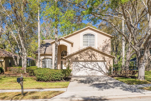 view of front of house with a front yard, concrete driveway, an attached garage, and stucco siding