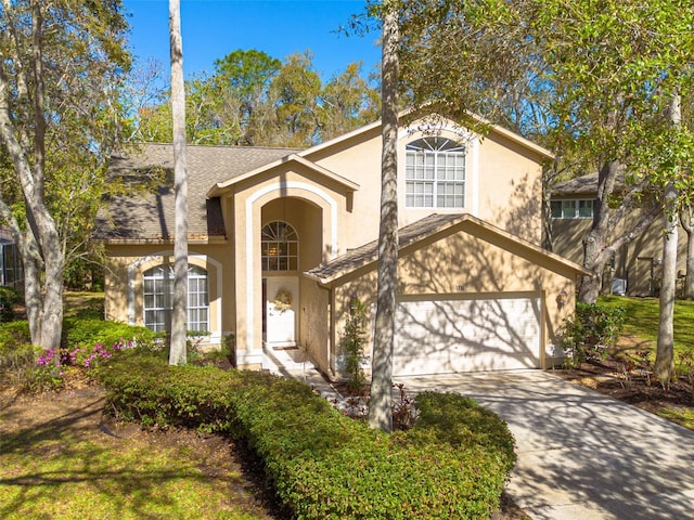 view of front of house with a garage, a shingled roof, concrete driveway, and stucco siding