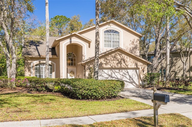 view of front facade with a garage, driveway, a front lawn, and stucco siding