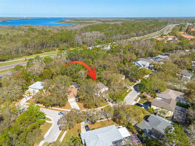 drone / aerial view featuring a water view and a wooded view