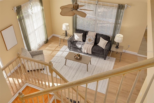 living room featuring stairway, baseboards, and wood finished floors