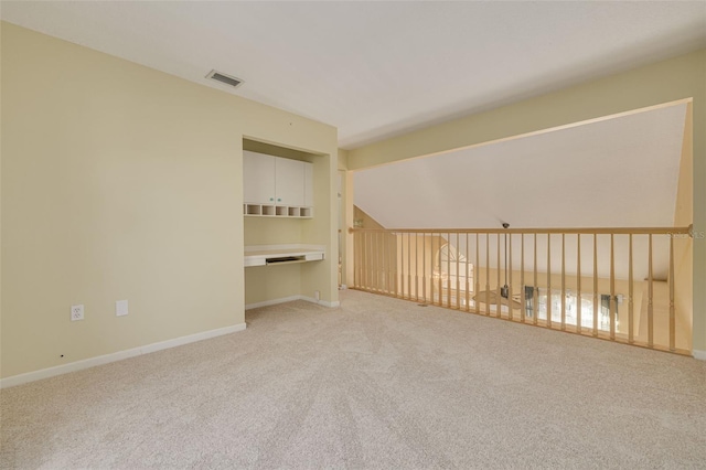 spare room with baseboards, visible vents, and light colored carpet