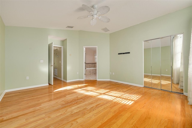 unfurnished bedroom featuring light wood-style flooring, baseboards, and a closet