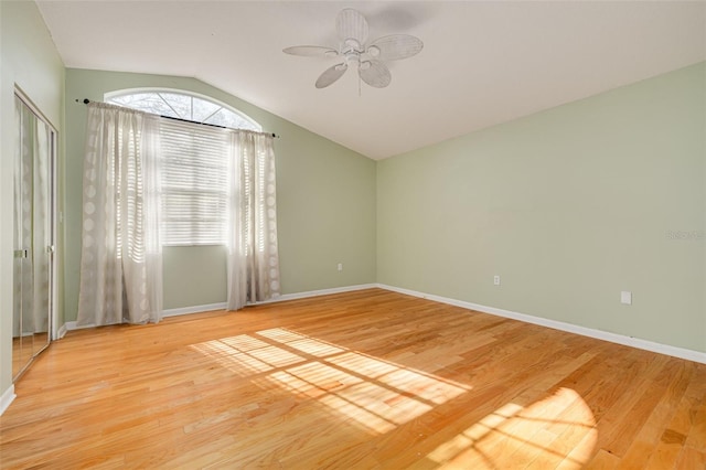 unfurnished room featuring lofted ceiling, a ceiling fan, baseboards, and wood finished floors