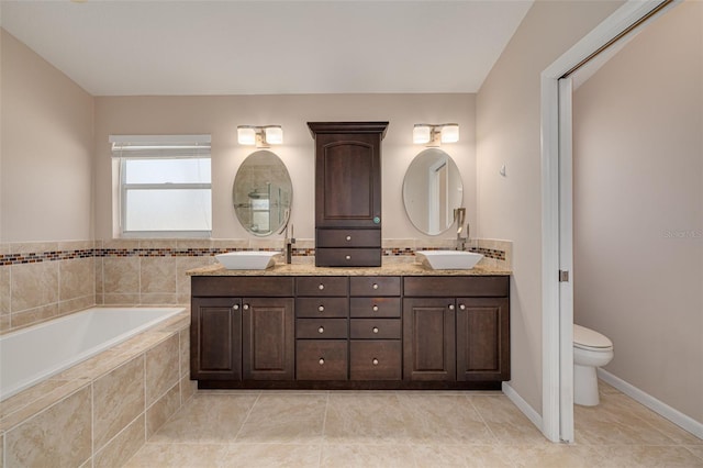 full bath featuring a garden tub, double vanity, a sink, and toilet