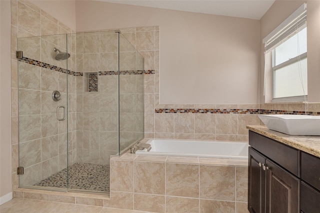 bathroom featuring tile patterned flooring, a garden tub, vanity, and a shower stall