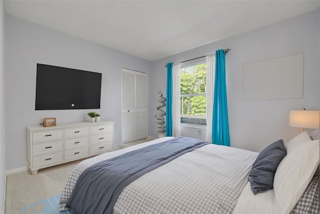 bedroom featuring a closet, light carpet, and baseboards