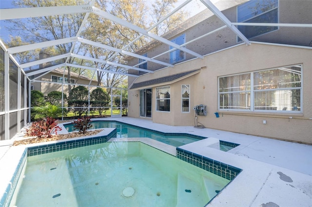 outdoor pool featuring a lanai, a patio area, and an in ground hot tub