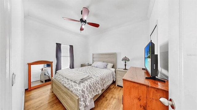 bedroom with ceiling fan, light wood-type flooring, and crown molding