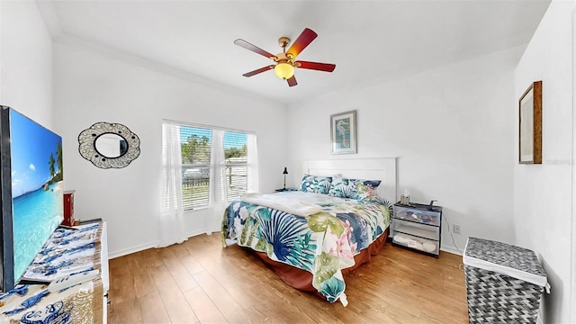 bedroom featuring ceiling fan, baseboards, and wood finished floors