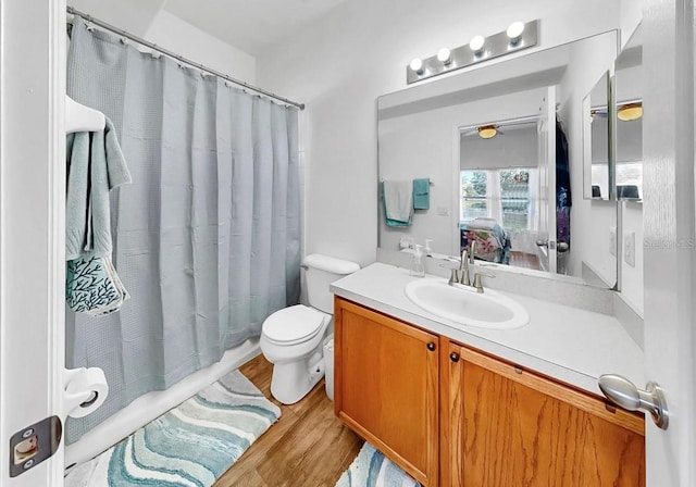 bathroom featuring a ceiling fan, toilet, ensuite bath, wood finished floors, and vanity